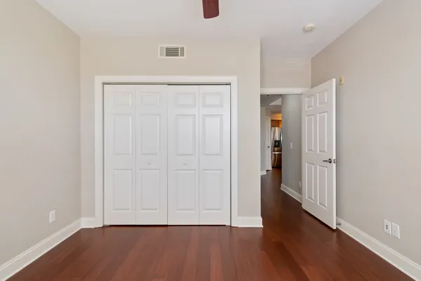 an empty room with wooden floor and closet