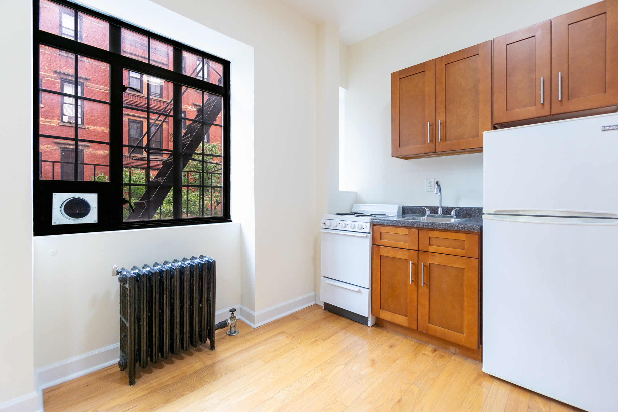 189 West 10th Street, Unit 2E Manhattan, NY 10014 - Photo 3 of 5 a kitchen with stainless steel appliances granite countertop a refrigerator a stove and a sink with cabinets