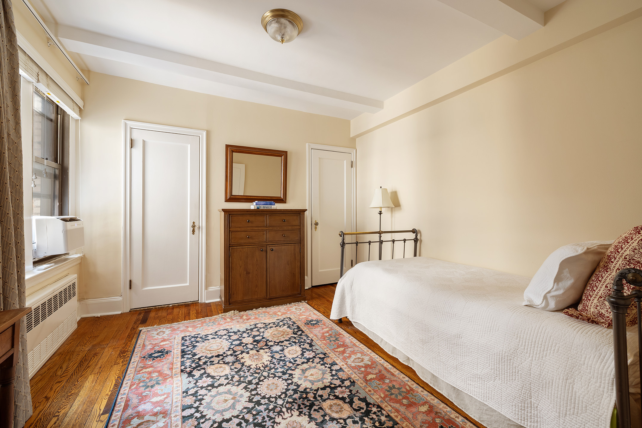 151 East 83rd Street, Unit 6D Manhattan, NY 10028 - Photo 9 of 14 a bedroom with a bed and wooden floor