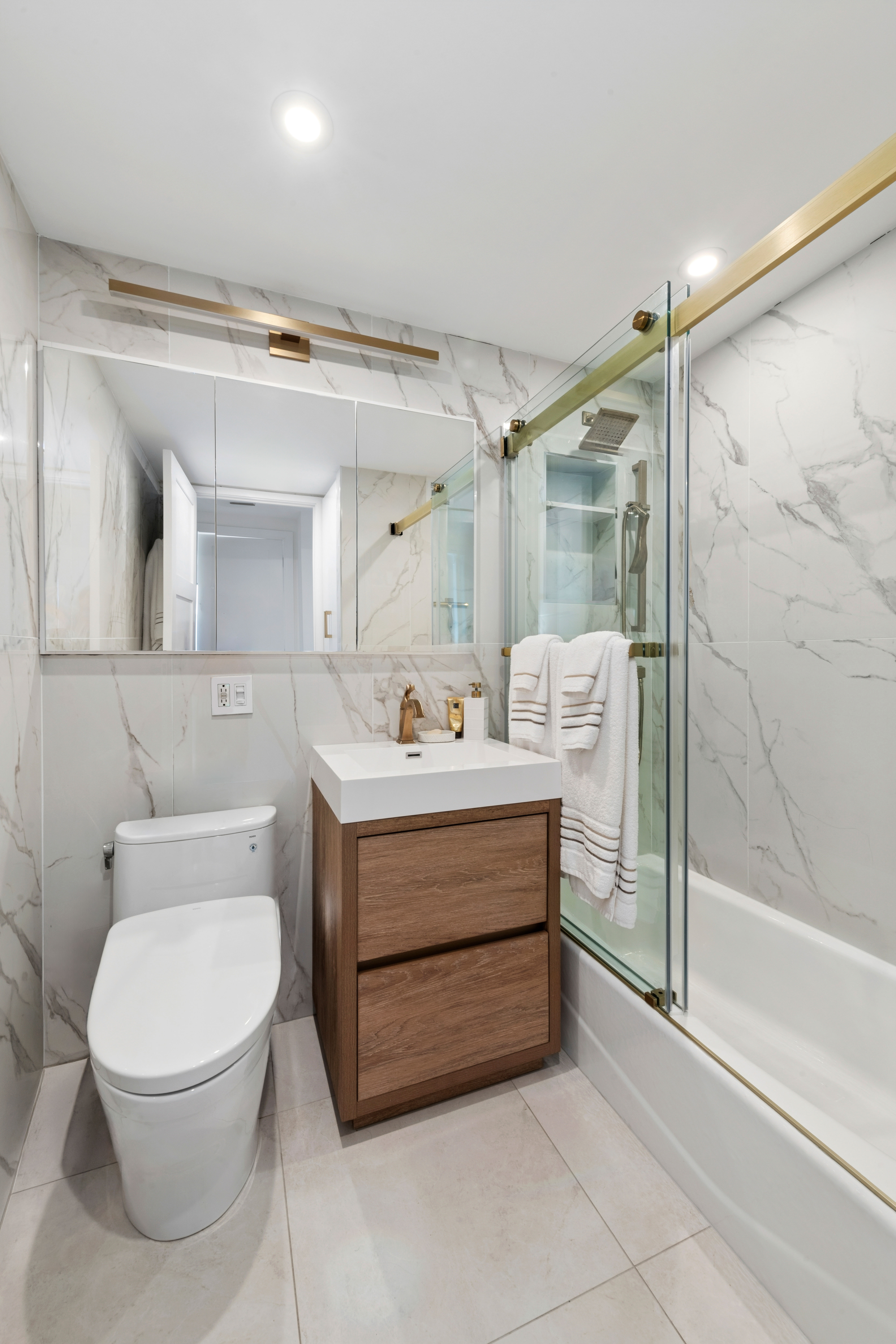 100 Beekman Street, Unit 26D Manhattan, NY 10038 - Photo 7 of 9 a bathroom with a sink mirror vanity and toilet