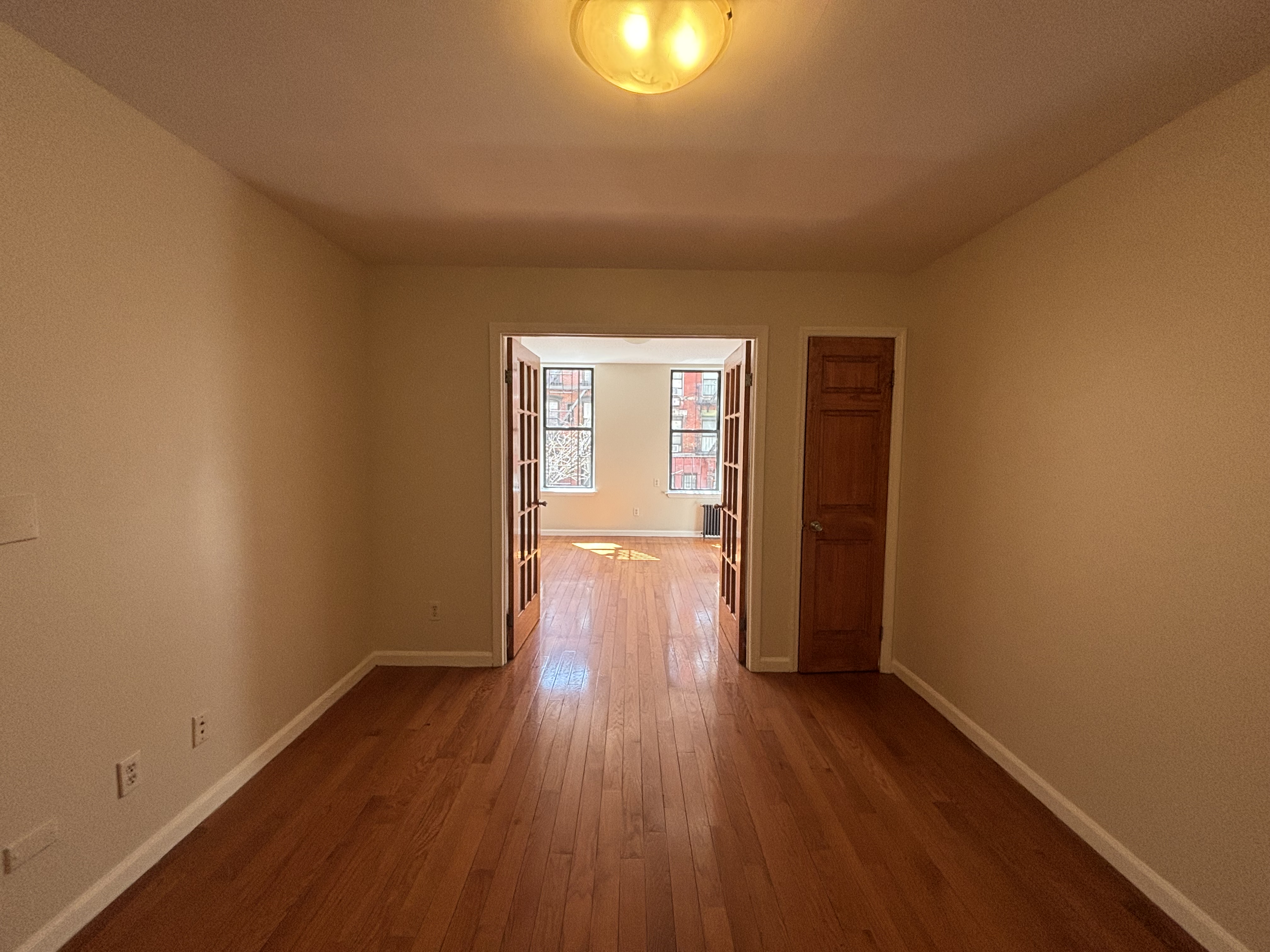 99 St Marks Place, Unit 4B Manhattan, NY 10009 - Photo 3 of 10 a view of a room with wooden floor and window