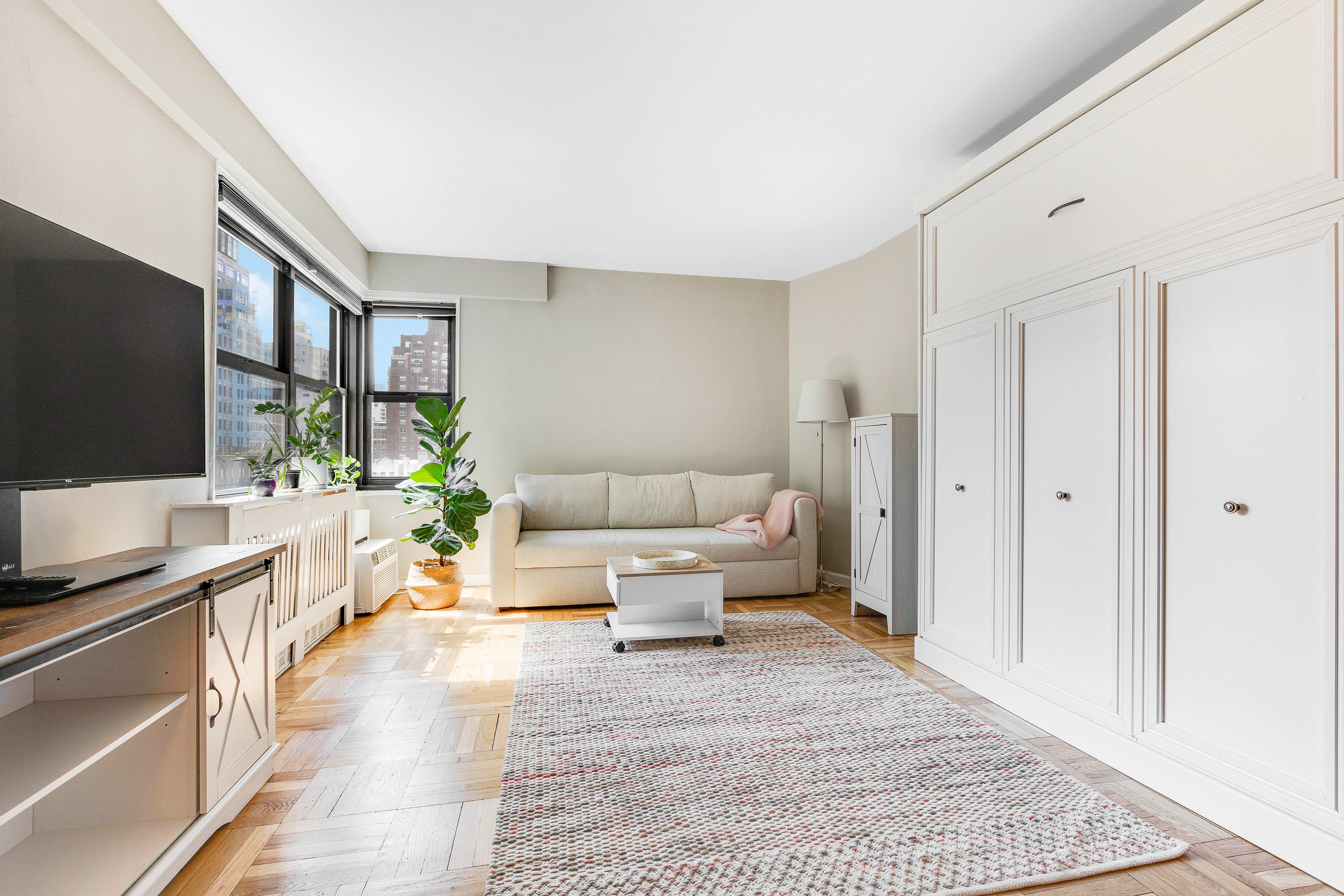 240 East 76th Street, Unit 9A Manhattan, NY 10021 - Photo 4 of 9 a living room with furniture and a flat screen tv
