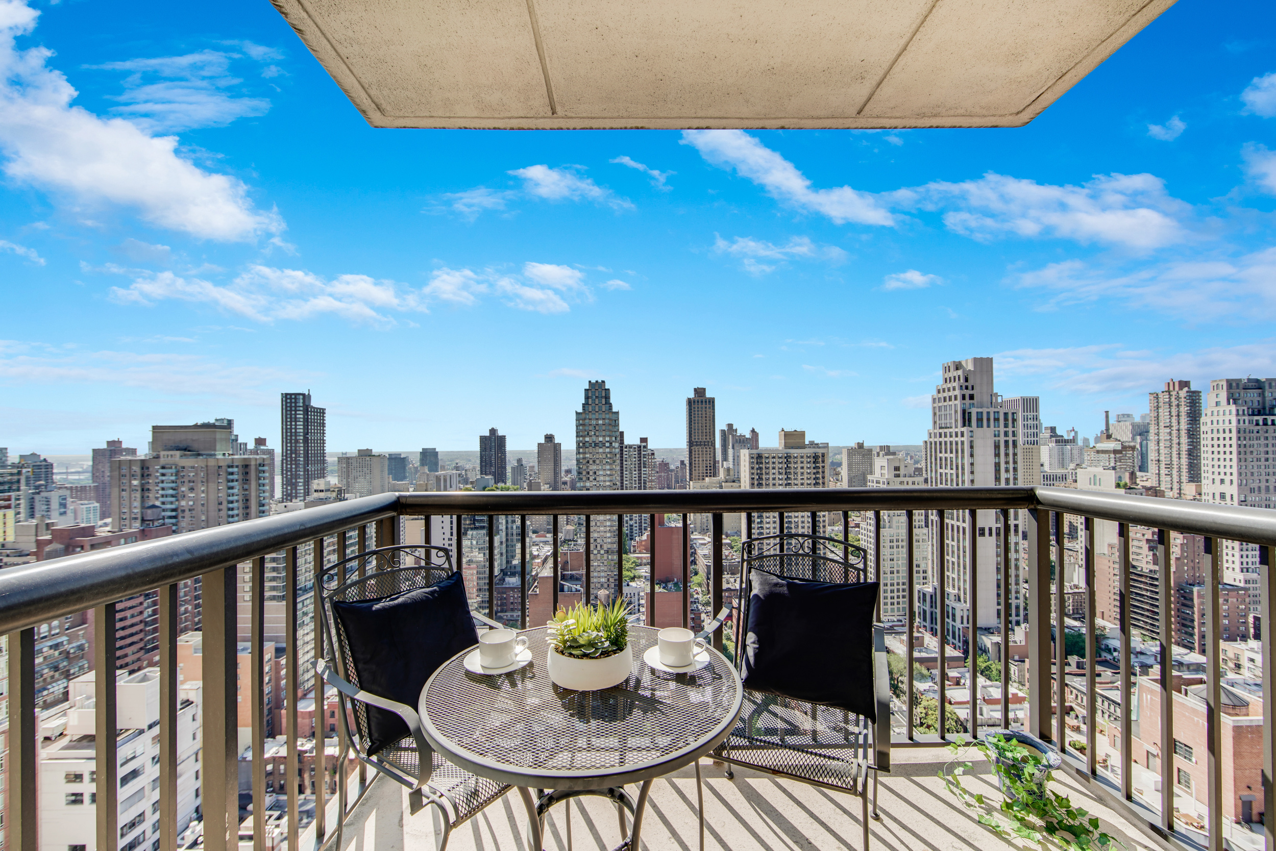 171 East 84th Street, Unit 31C Manhattan, NY 10028 - Photo 13 of 18 a view of a balcony with a dining table and chairs