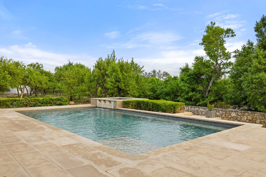 2560 Bell Springs Road Dripping Springs, TX 78620 - Photo 18 of 42 a view of a swimming pool with a yard