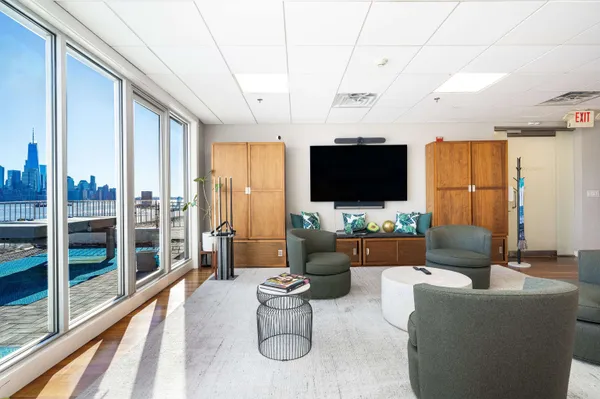 a living room with furniture a flat screen tv and a floor to ceiling window