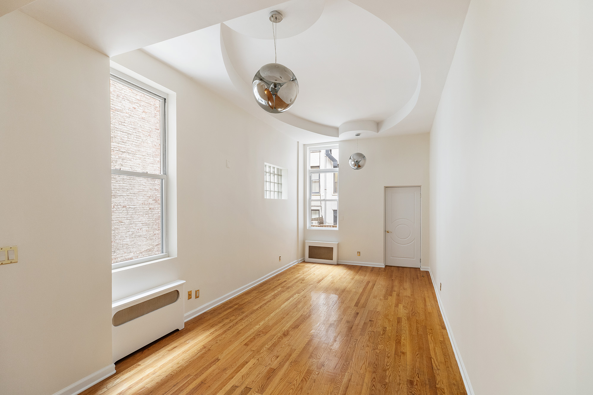 23 East 81st Street, Unit 1 Manhattan, NY 10028 - Photo 9 of 23 a view of a room with wooden floor and a large window