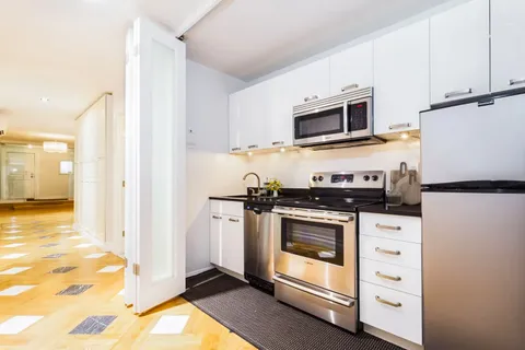 a kitchen with stainless steel appliances granite countertop a stove a refrigerator and a microwave