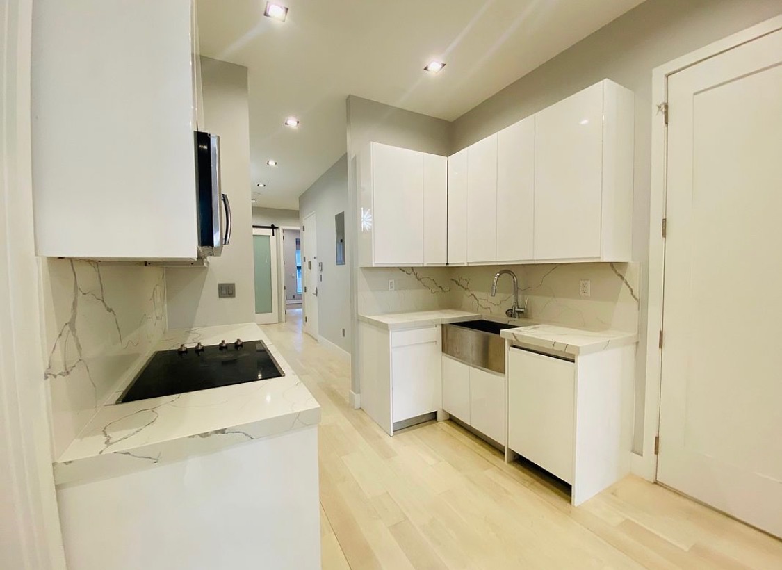 133 East 35th Street, Unit 3 Manhattan, NY 10016 - Photo 5 of 16 a kitchen with a white stove top oven and white cabinets