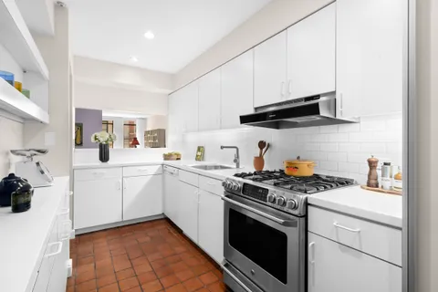 a kitchen with stainless steel appliances granite countertop a sink a stove and cabinets
