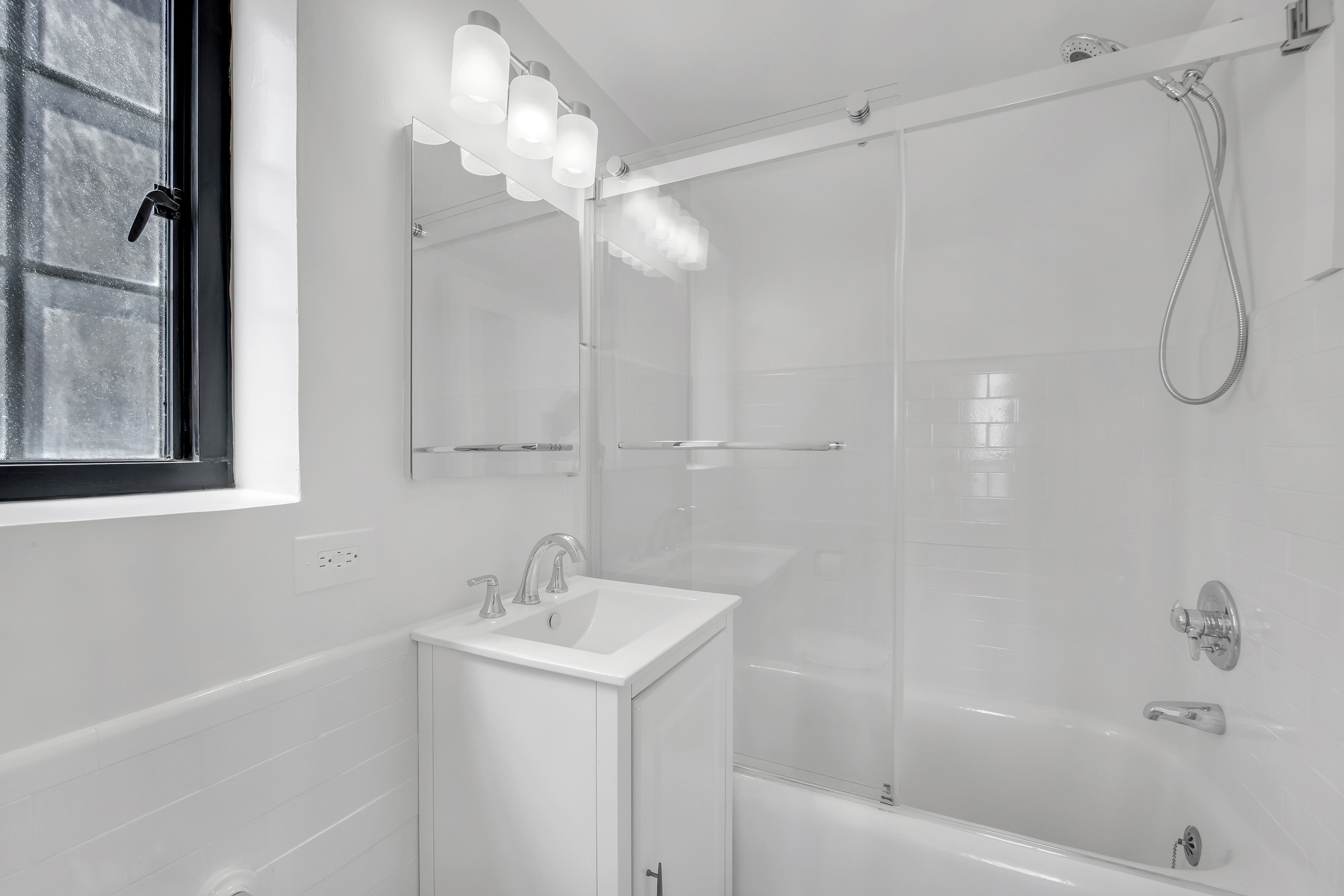 5 Tudor City Place, Unit 625 Manhattan, NY 10017 - Photo 8 of 11 a bathroom with a bathtub a shower a sink and a vanity