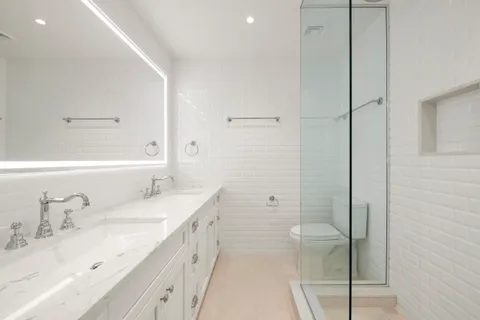 a bathroom with a double vanity sink toilet mirror and bathtub