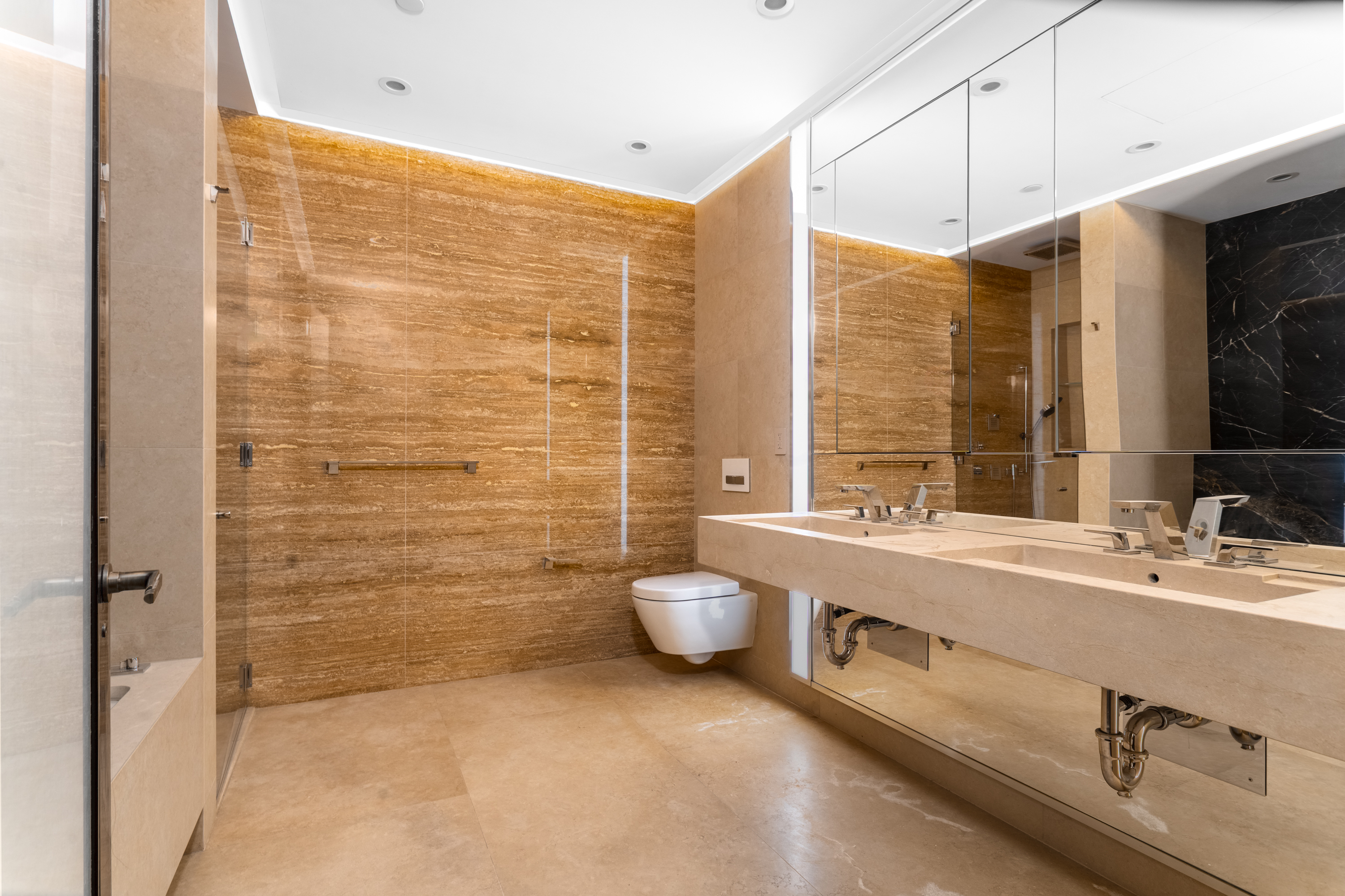 53 West 53rd Street, Unit 20E Manhattan, NY 10019 - Photo 7 of 11 a bathroom with a granite countertop sink a toilet and shower