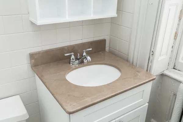 a bathroom with a granite countertop sink a toilet and bathtub