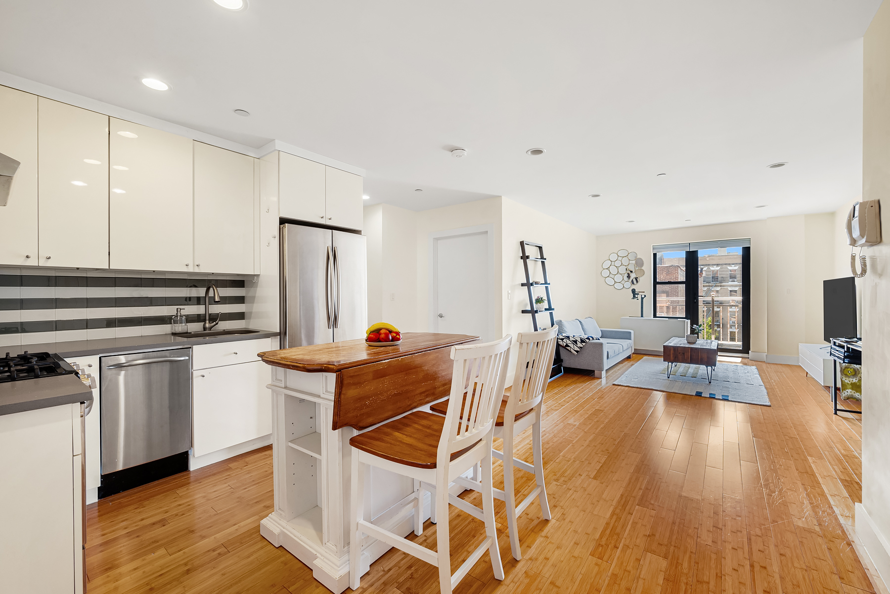 234 West 148th Street, Unit 5C Manhattan, NY 10039 - Photo 2 of 15 a living room with stainless steel appliances granite countertop a stove a sink dishwasher and a refrigerator with wooden floor