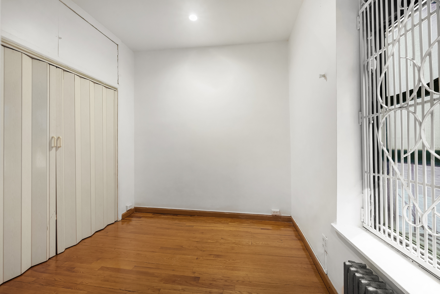 786 9th Avenue, Unit 2R Manhattan, NY 10019 - Photo 5 of 9 a view of a room with wooden floor and a railing