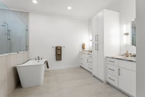 a spacious bathroom with a double vanity sink a mirror and a bathtub