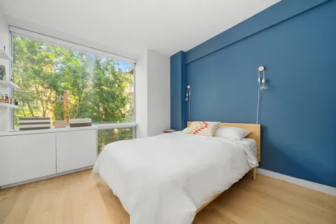 a bedroom with a bed and a large window