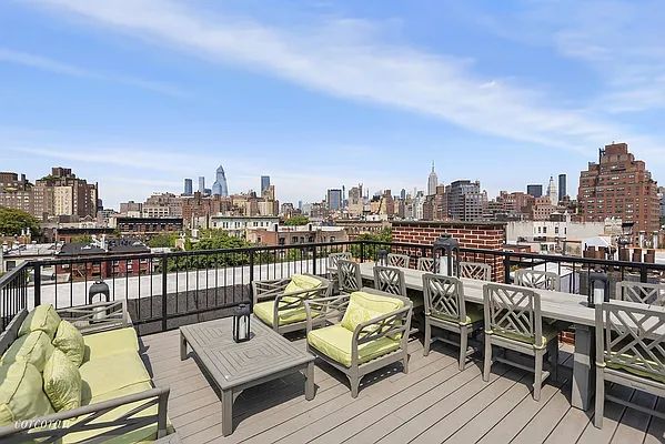 a view of a rooftop deck with chairs and wooden floor