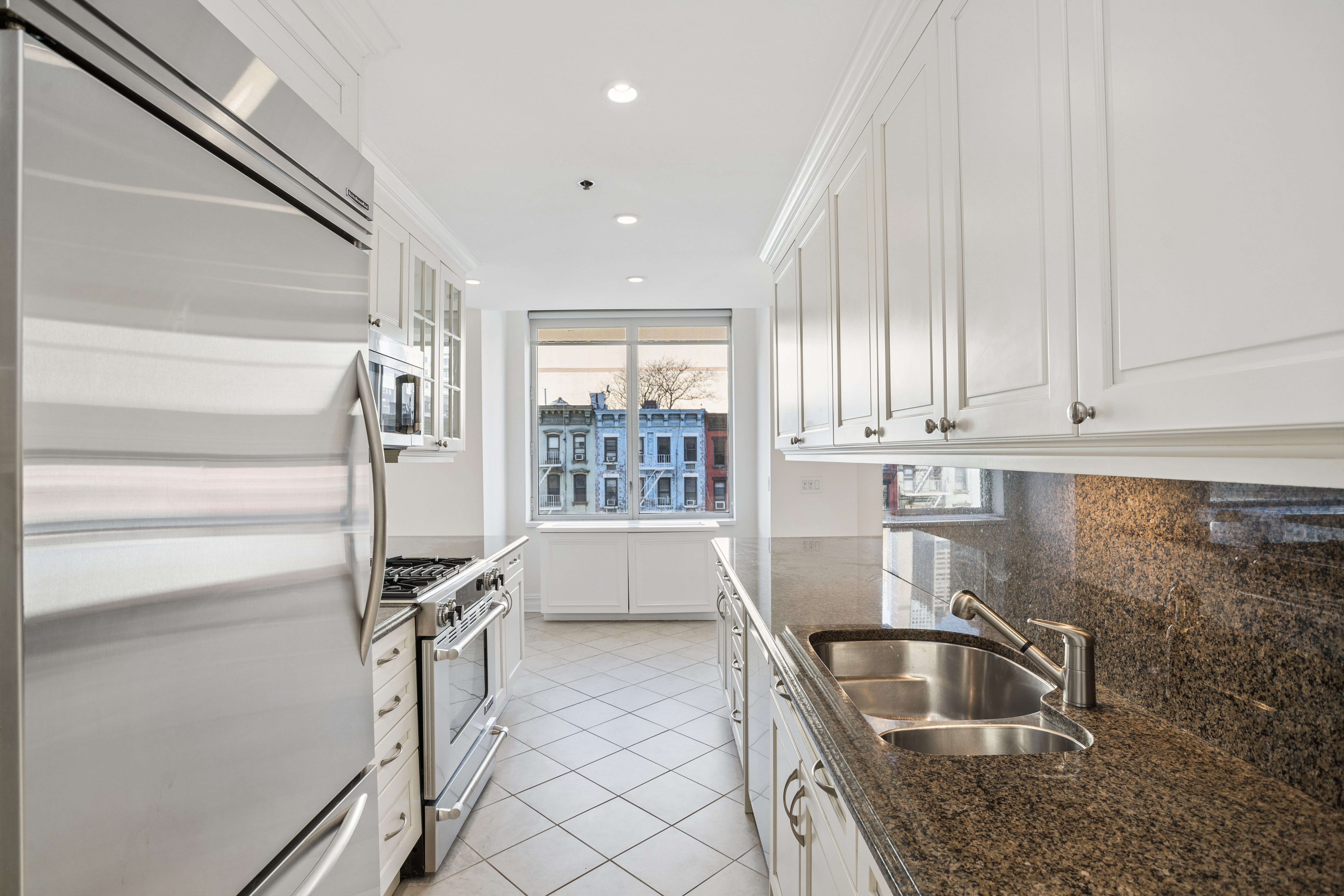 401 East 60th Street, Unit 4ABC Manhattan, NY 10022 - Photo 2 of 18 a kitchen with granite countertop a sink and a stove top oven