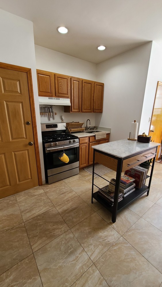 562 Fairview Avenue, Unit 1R Queens, NY 11385 - Photo 4 of 11 a kitchen with stainless steel appliances granite countertop a stove a sink and a refrigerator