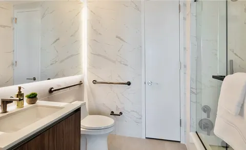 a bathroom with a sink a toilet and shower