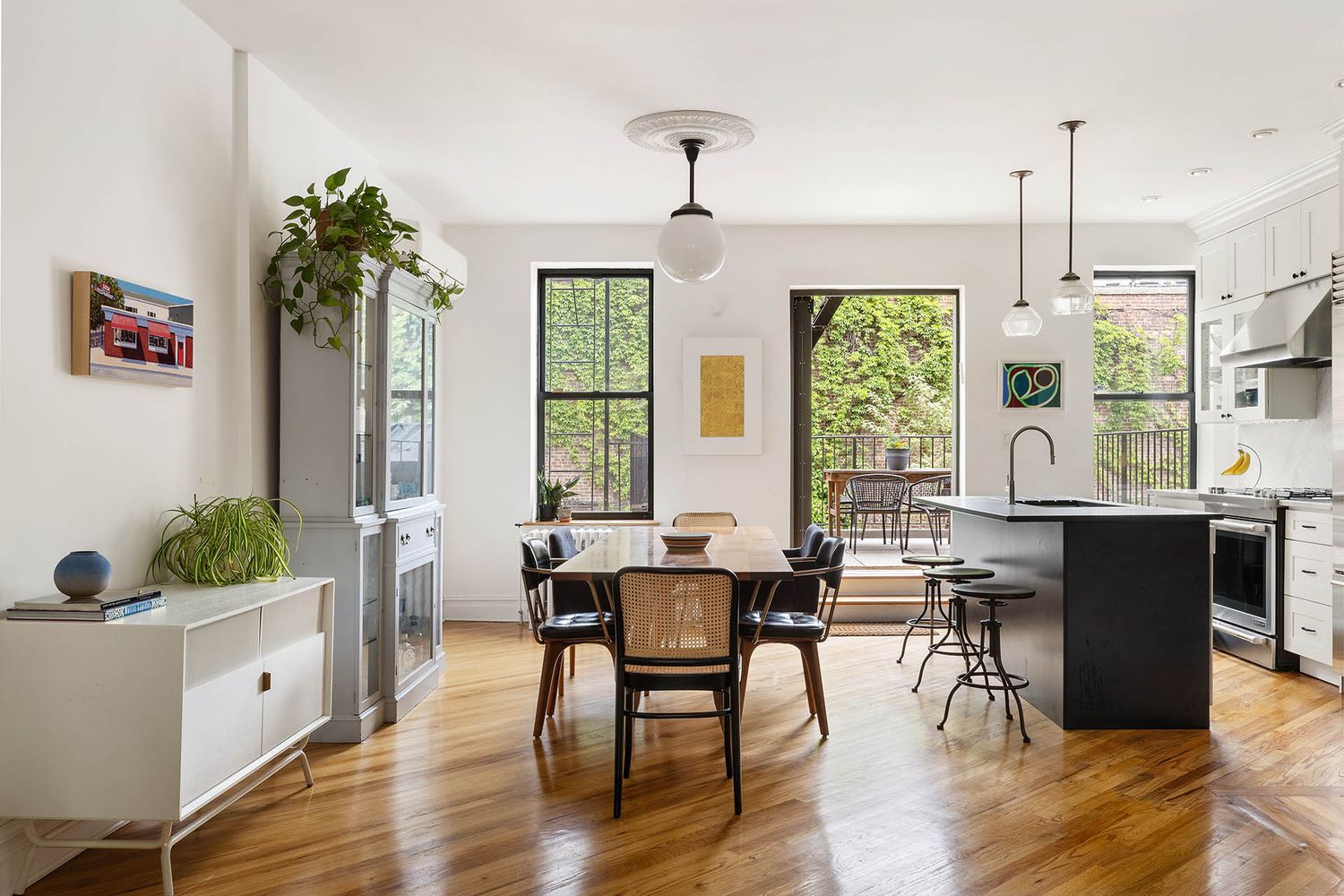 a dining room with wooden floor a chandelier a wooden table and chairs