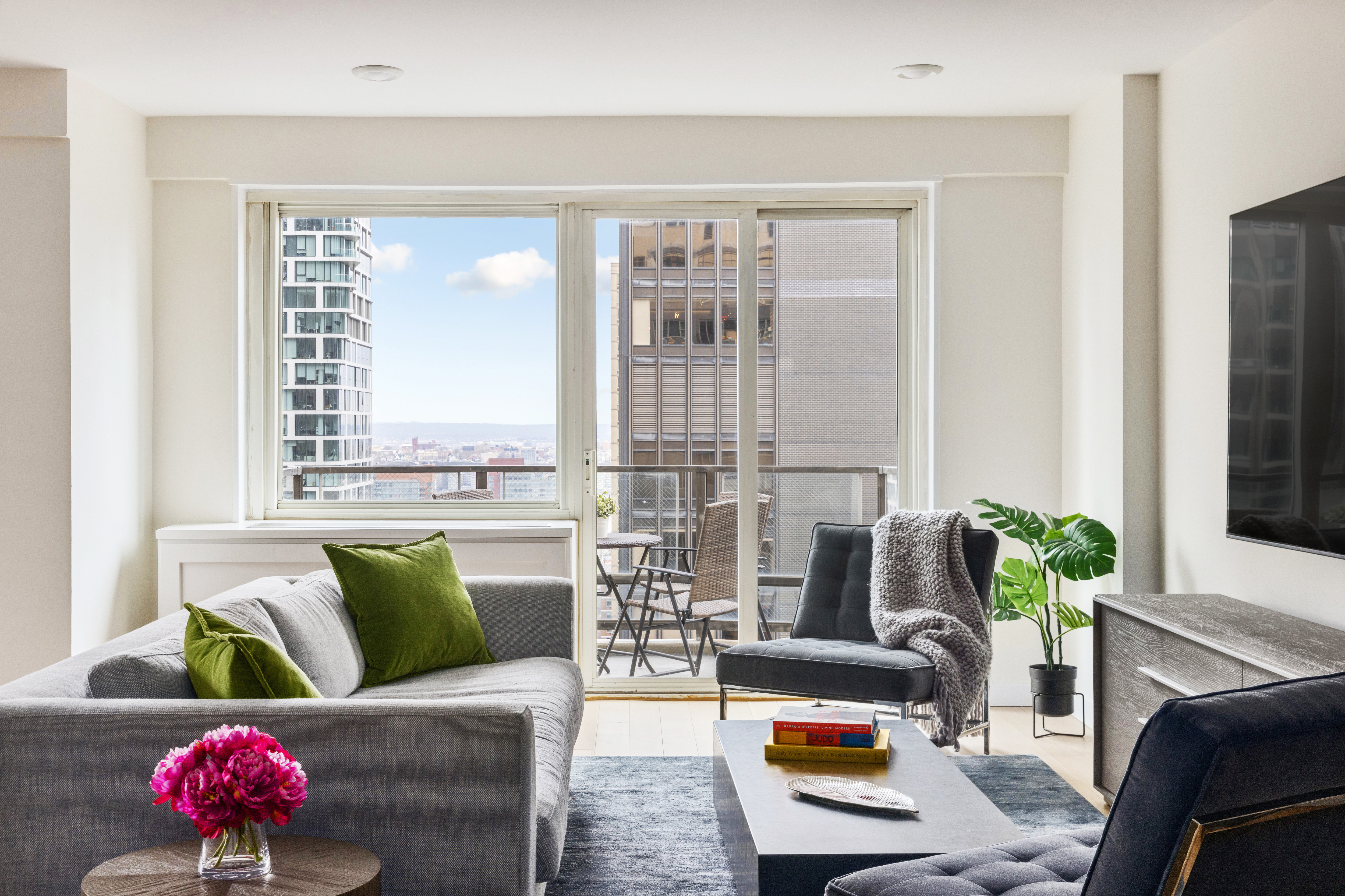 159 West 53rd Street, Unit 34E Manhattan, NY 10019 - Photo 1 of 15 a living room with furniture and a large window