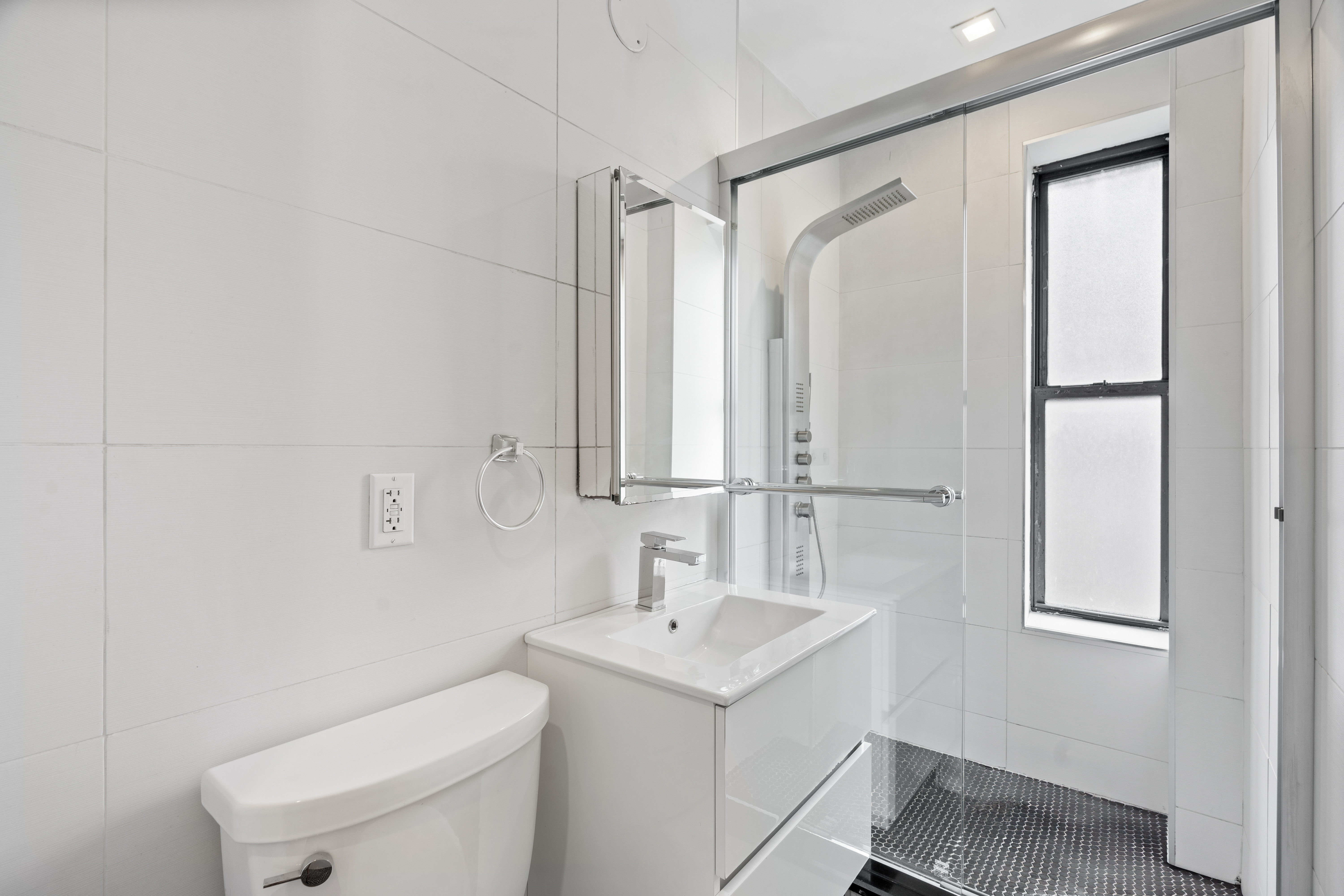 140 Orchard Street, Unit 14 Manhattan, NY 10002 - Photo 8 of 9 a bathroom with a sink a toilet and a mirror