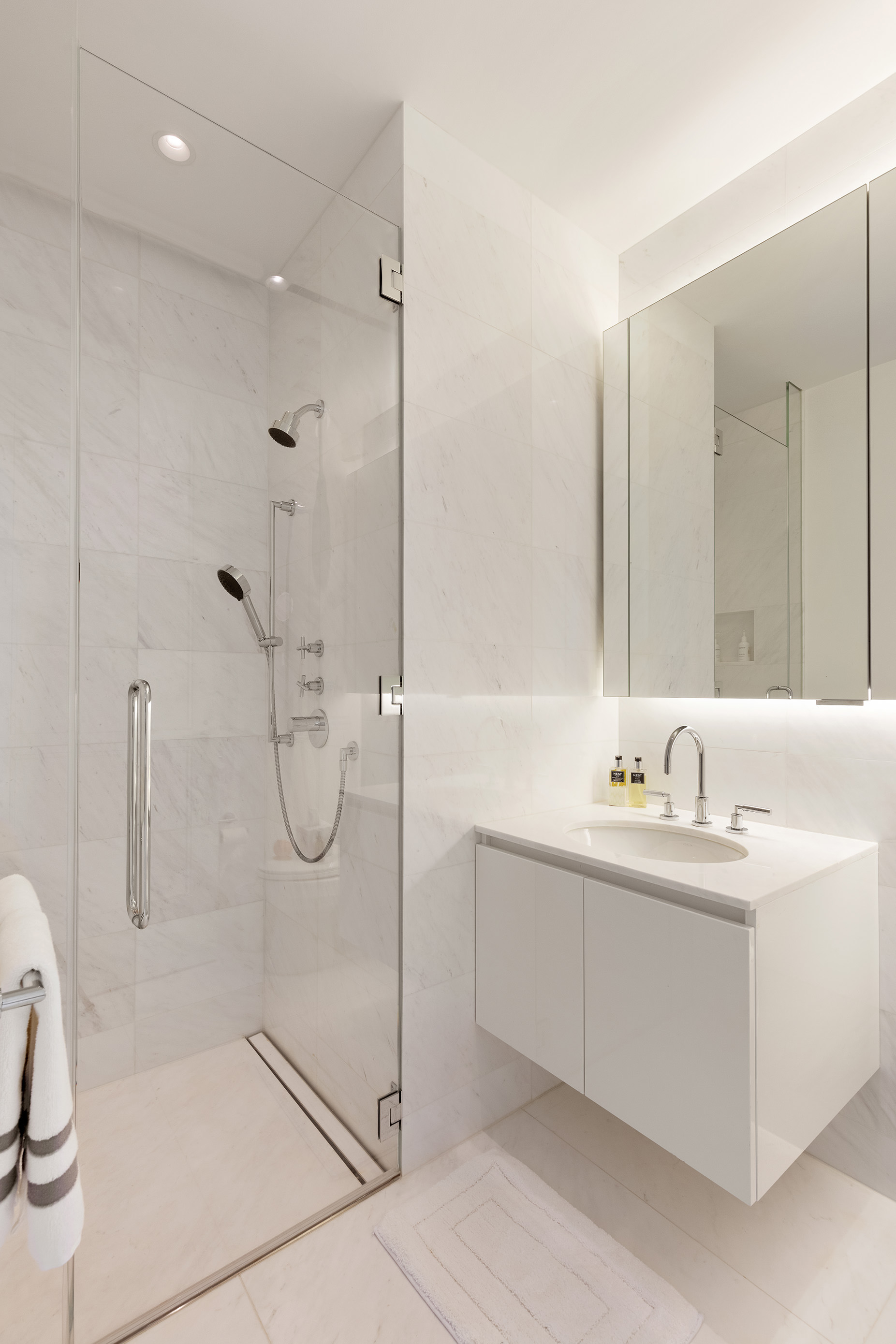 432 Park Avenue, Unit 81A Manhattan, NY 10022 - Photo 11 of 12 a bathroom with a double vanity sink a toilet and shower