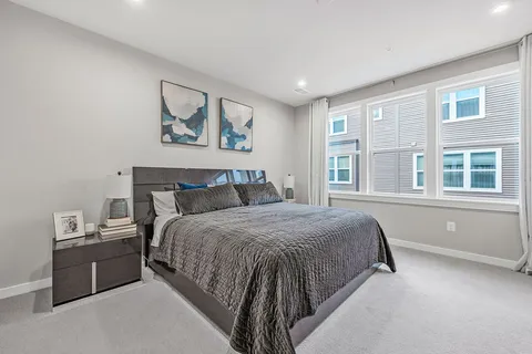 a bed sitting in a bedroom next to a window