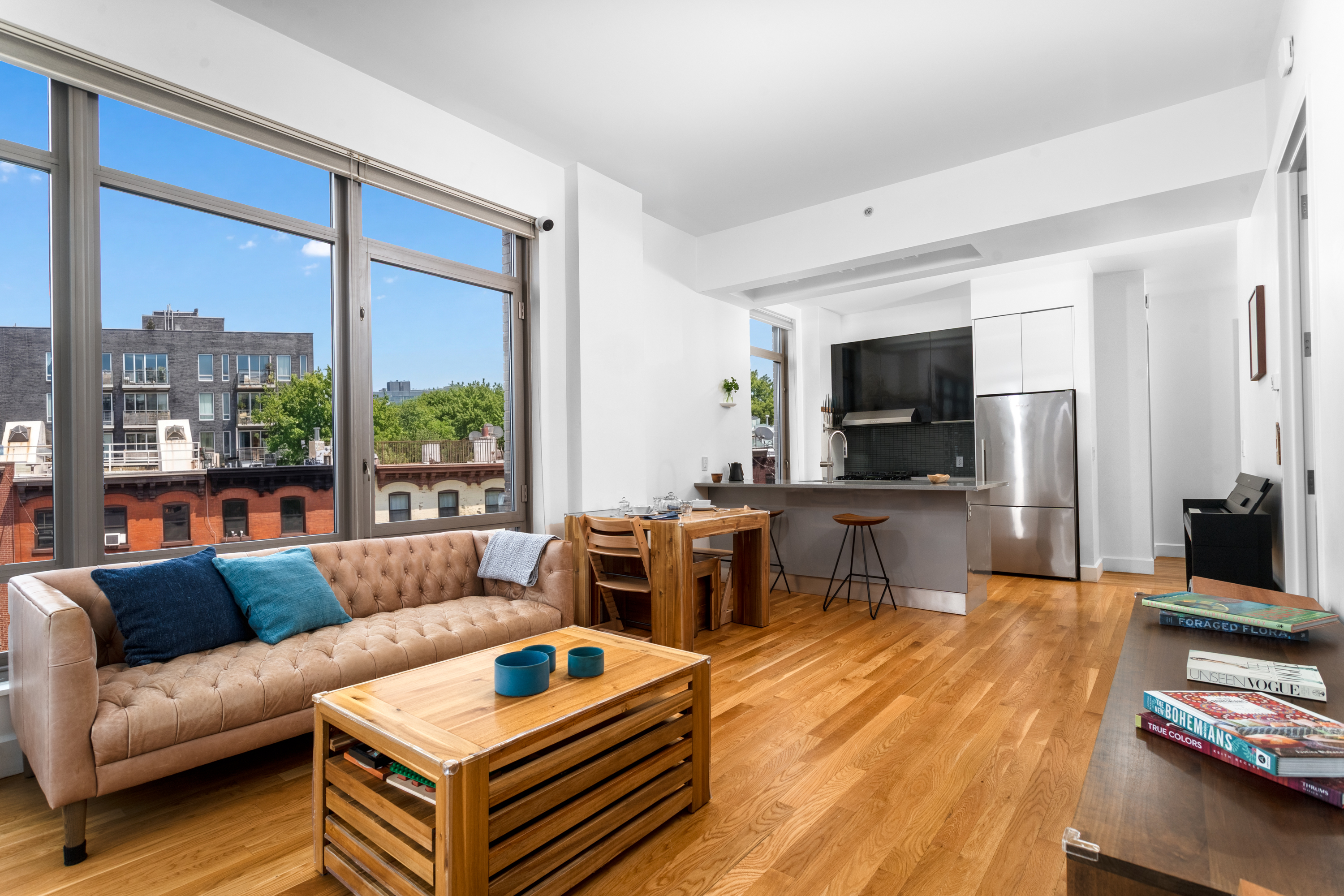 315 Gates Avenue, Unit 4E Brooklyn, NY 11216 - Photo 3 of 17 a living room with furniture a flat screen tv and a floor to ceiling window