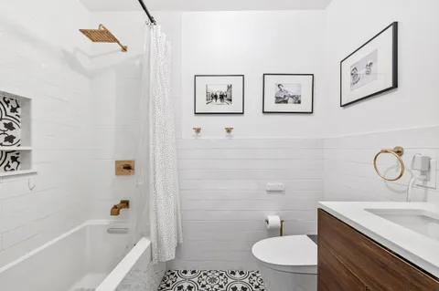 a bathroom with a granite countertop sink mirror vanity and toilet