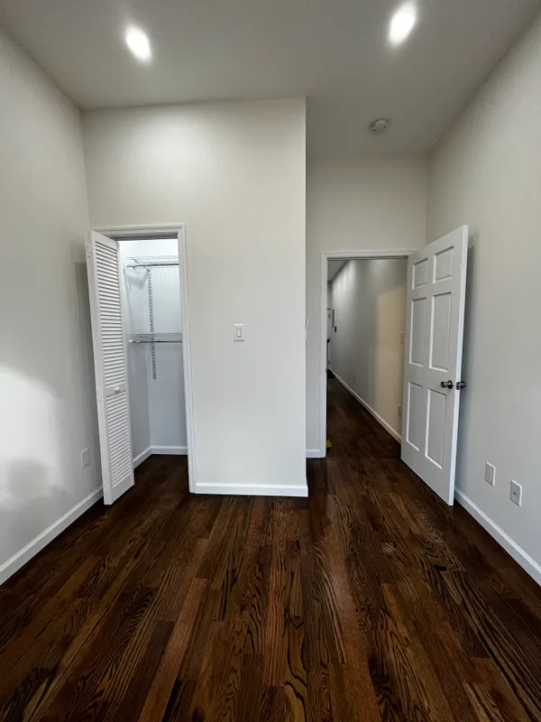 an empty room with wooden floor and closet