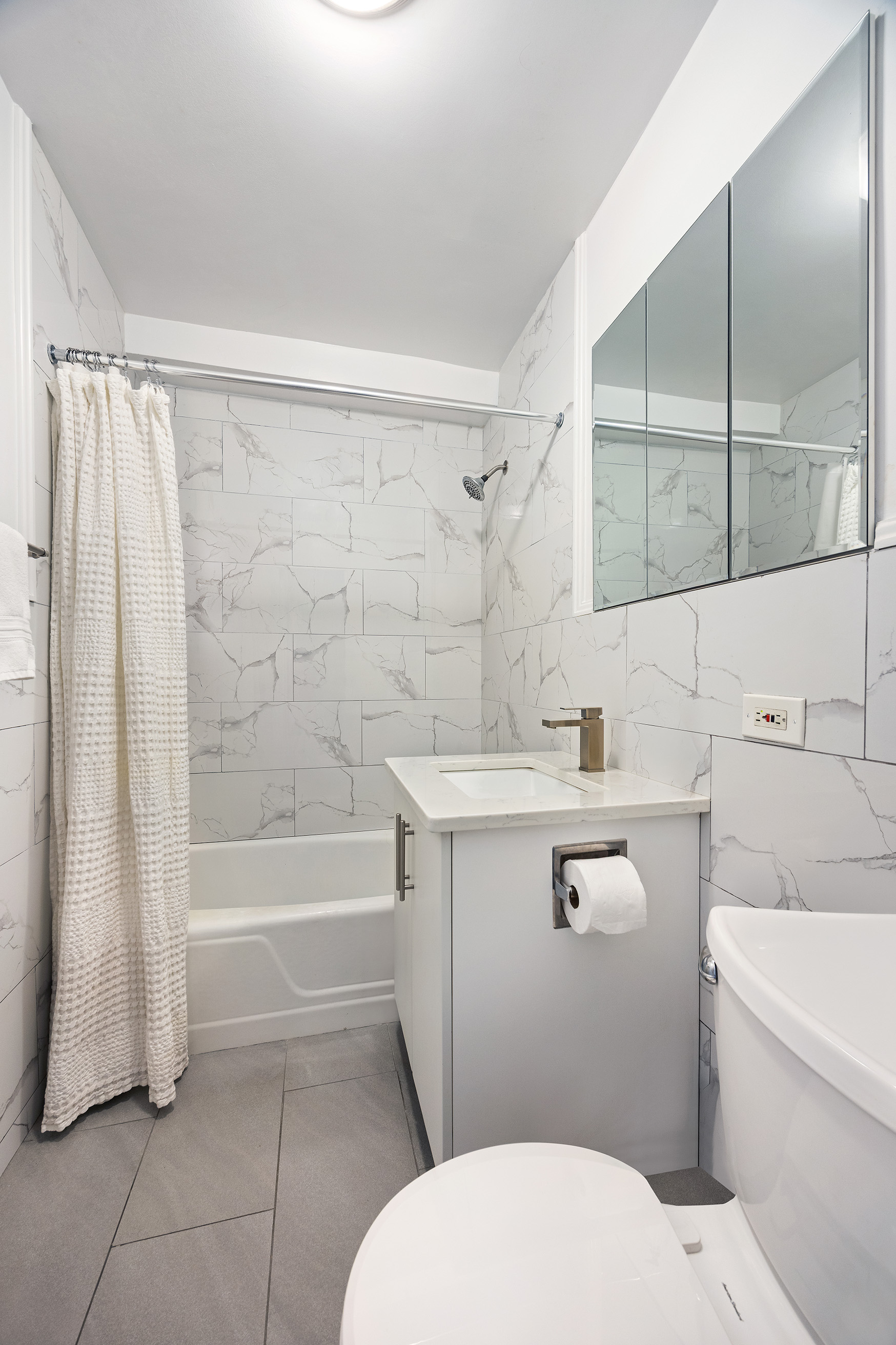 120 East 90th Street, Unit 7A Manhattan, NY 10128 - Photo 7 of 8 a bathroom with a sink a toilet and shower