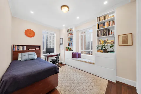 a bedroom with a large bed and a book shelf