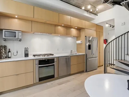 a kitchen with cabinets and stainless steel appliances