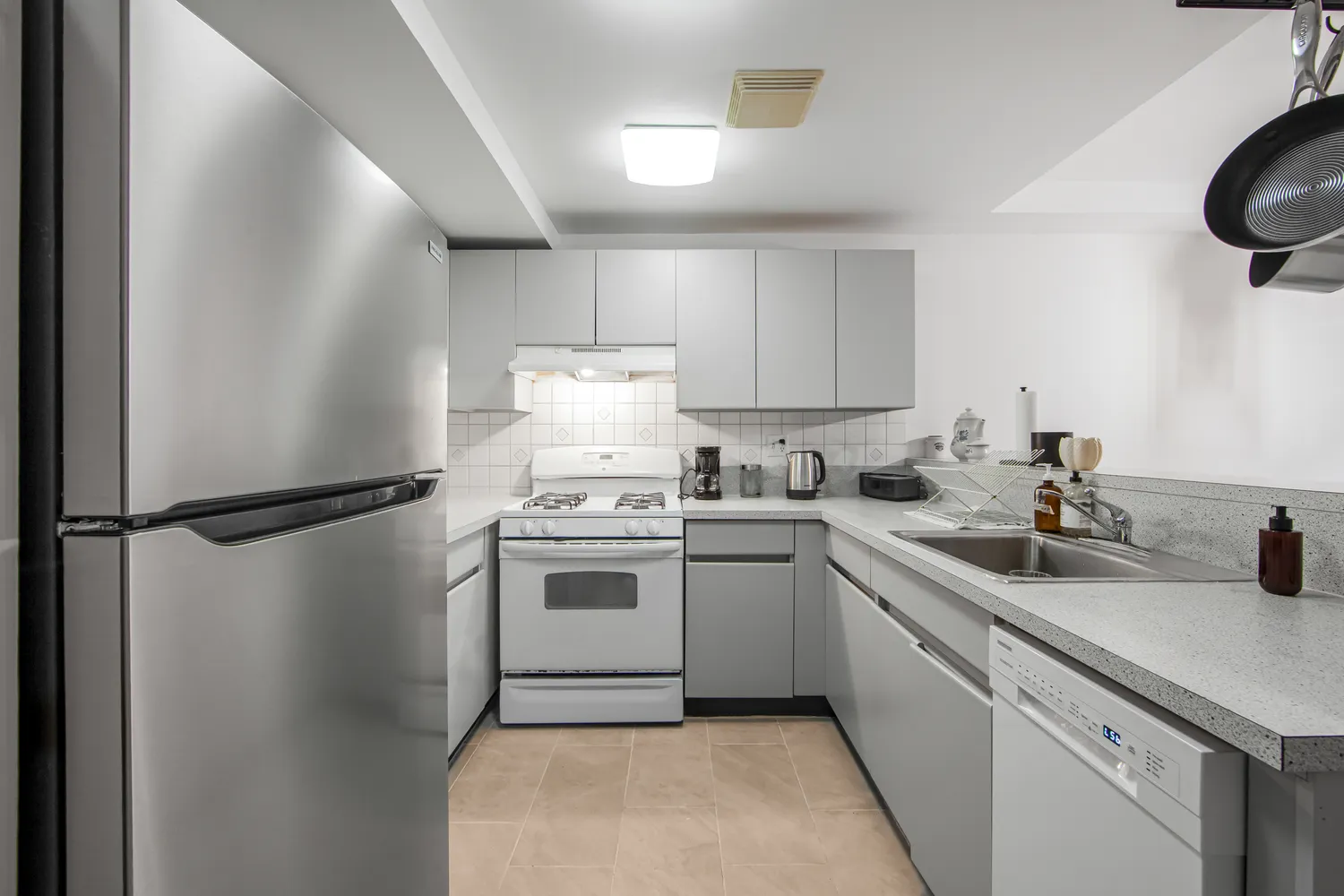 a kitchen with a sink a refrigerator and cabinets
