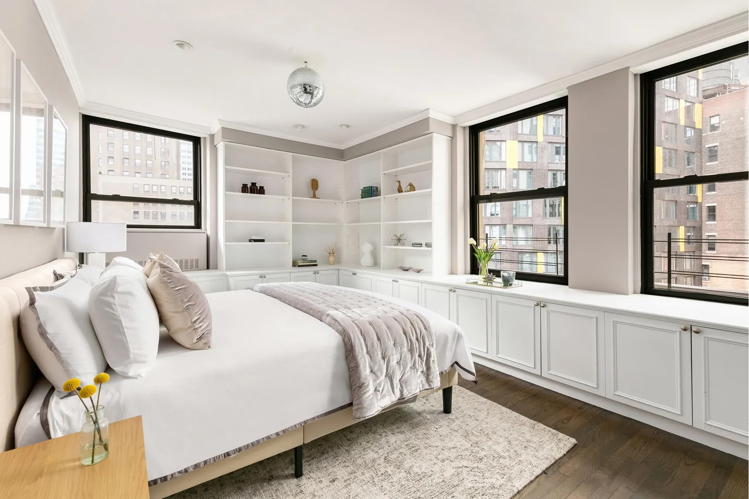 a bedroom with a bed and a large window with chair