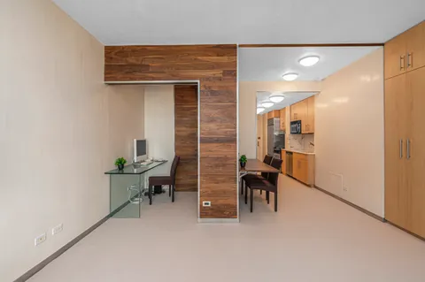 a kitchen with a sink dishwasher and white cabinets with wooden floor