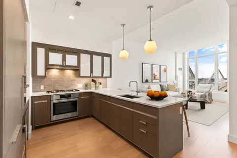 a kitchen with stainless steel appliances granite countertop a sink a stove and a wooden floor