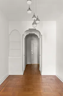 a view of a room with wooden floor and a ceiling fan