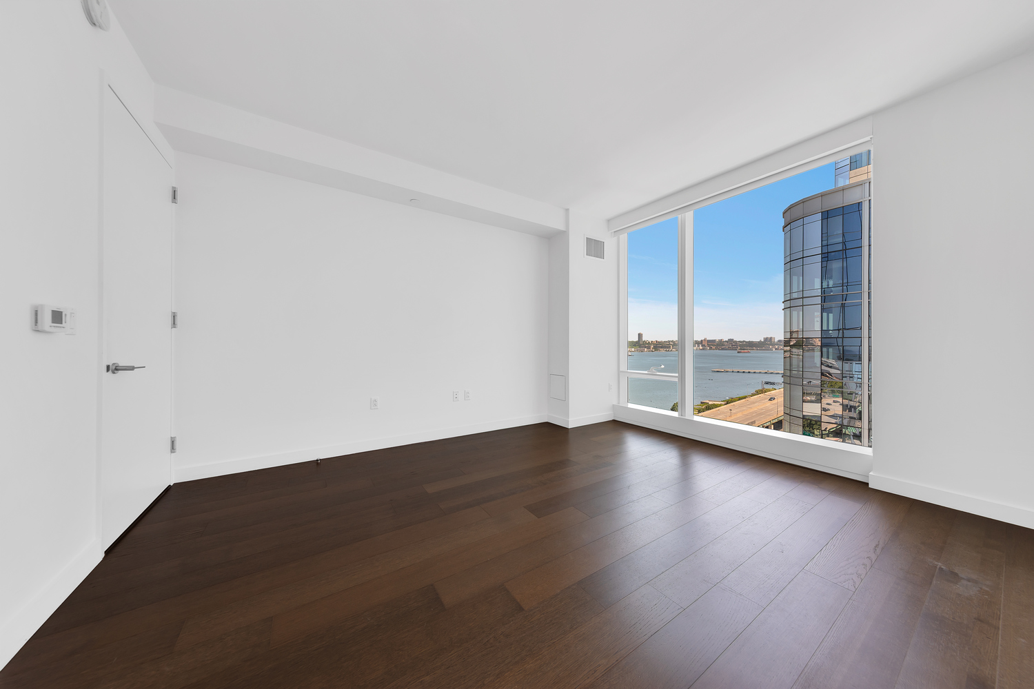 30 Riverside Boulevard, Unit 1414 Manhattan, NY 10069 - Photo 11 of 25 an empty room with wooden floor and windows