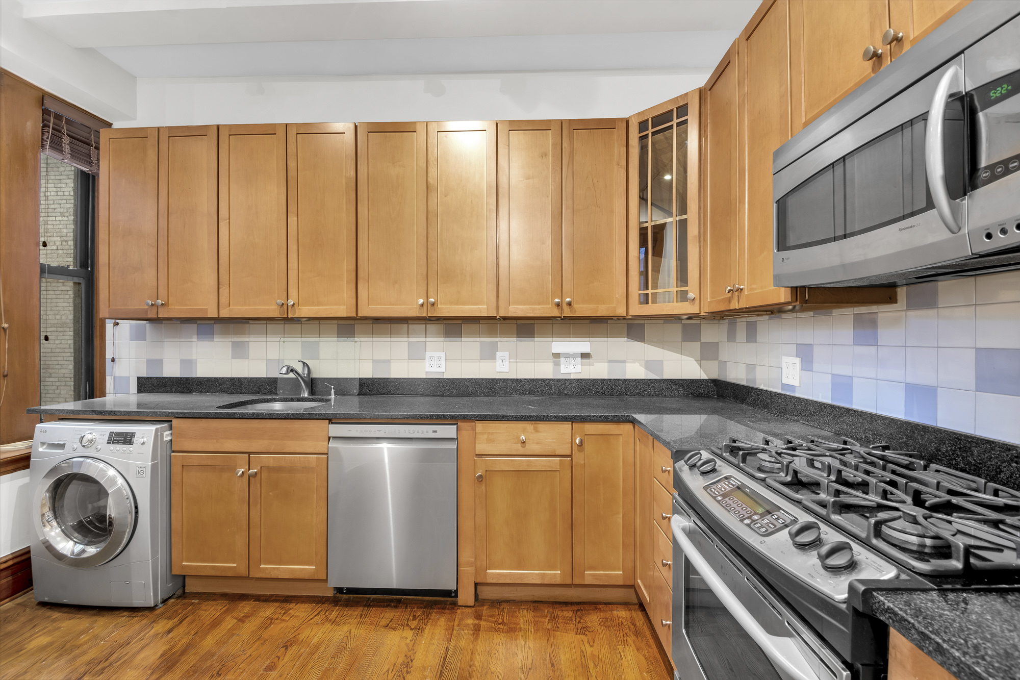 790 Riverside Drive, Unit 5F Manhattan, NY 10032 - Photo 8 of 12 a kitchen with wooden cabinets and a stove top oven