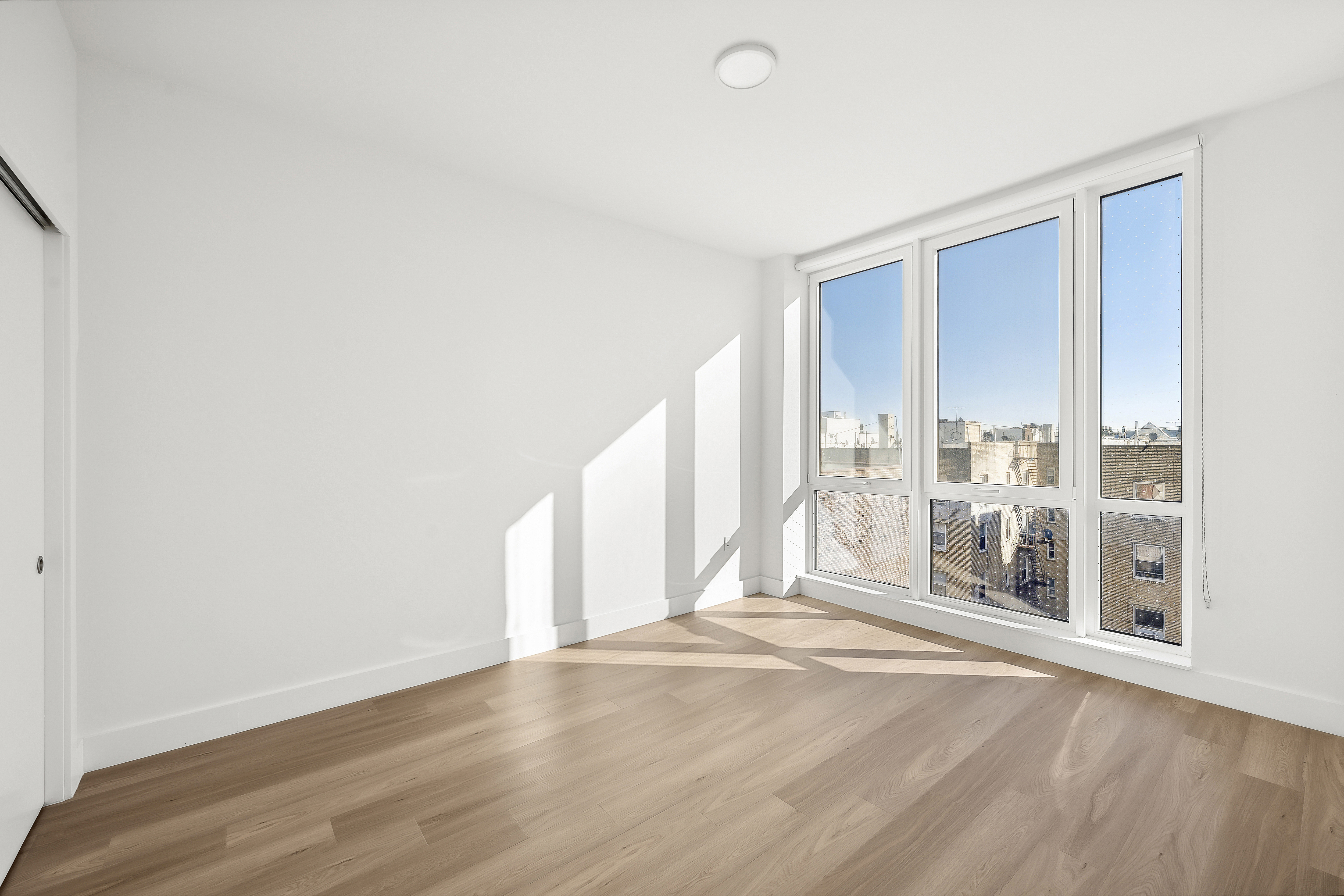 340 Lenox Road, Unit 6A Brooklyn, NY 11226 - Photo 3 of 26 a view of an empty room with wooden floor and a window