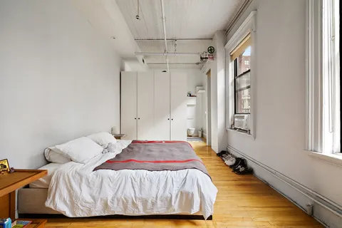 a bedroom with a bed and a window