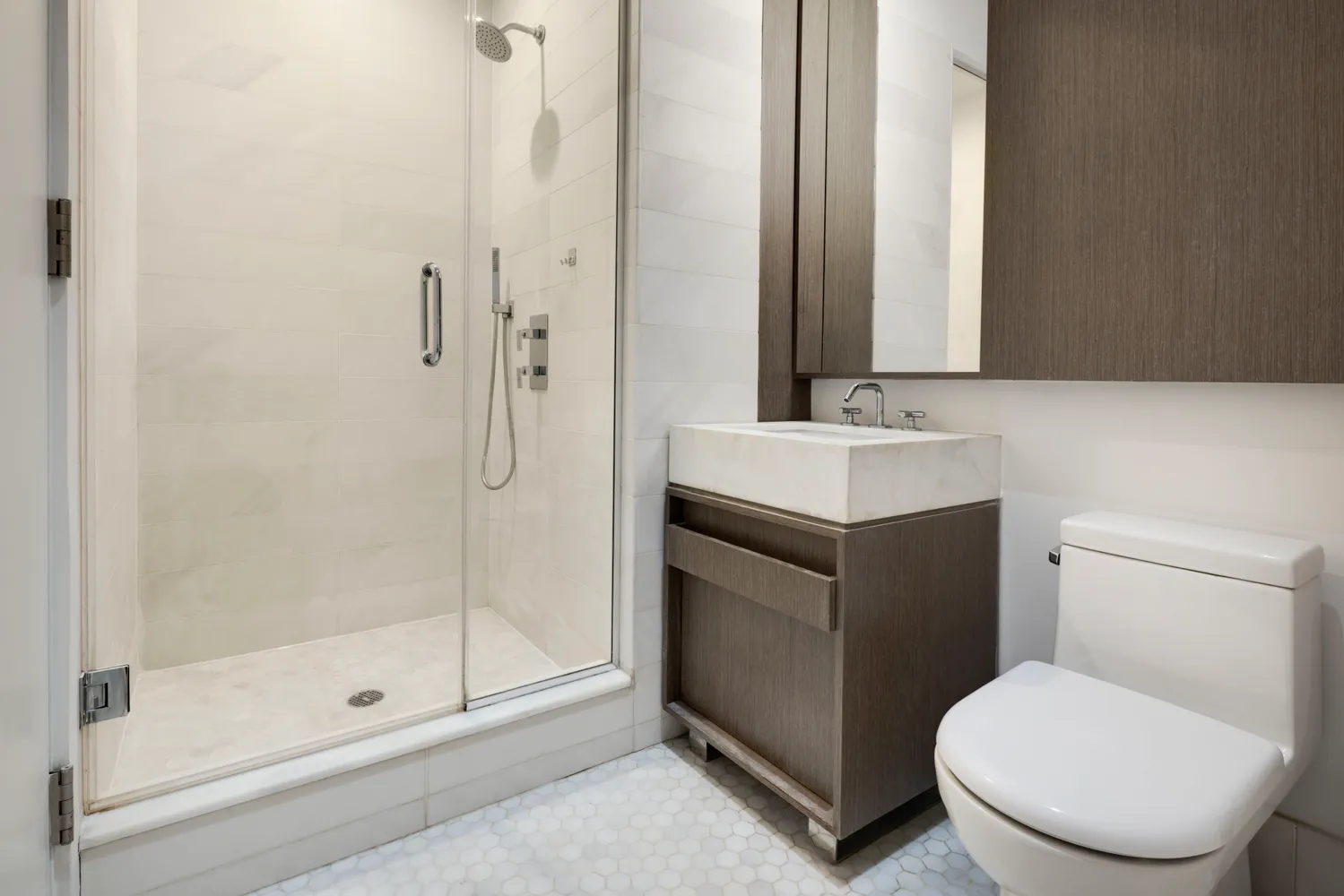 a bathroom with a toilet sink vanity and shower