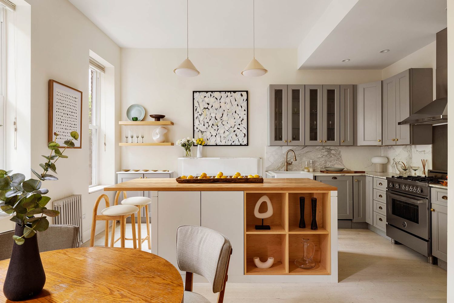 a kitchen with stainless steel appliances granite countertop a stove top oven a sink a dining table and chairs with wooden floor