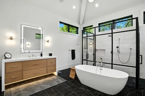 a bathroom with a granite countertop sink toilet a mirror a vanity and shower