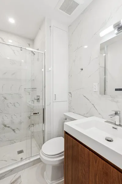 a bathroom with a sink a toilet and shower