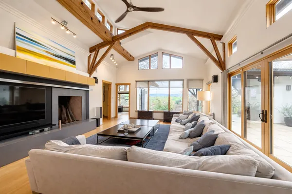 a living room with furniture fireplace and a large window